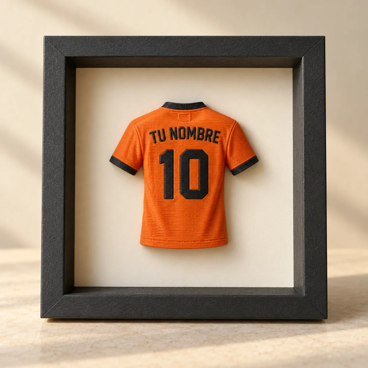 Concepto de camiseta naranja con nombre y dorsal en un marco negro